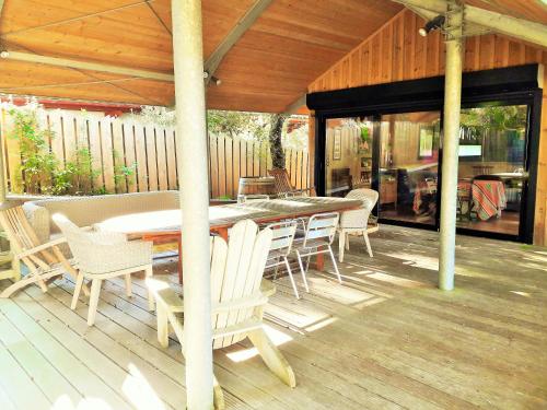 un patio avec une table et des chaises sur une terrasse dans l'établissement BELLEVUE Maison Atypique Grande Terrasse au Calme, à Pyla-sur-Mer