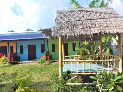 una casa con piscina y una choza de paja en Lanta Mother House, en Ko Lanta
