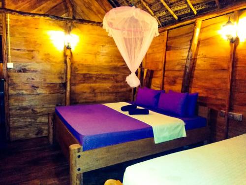 a bedroom with a bed in a wooden cabin at LakeSide Cabana Tissamaharama in Tissamaharama