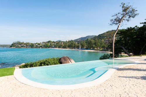 a swimming pool next to a body of water at The Shore At Katathani - Adult Only - SHA Extra Plus in Kata Beach