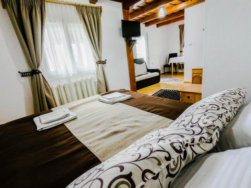 a bedroom with a large bed with two towels on it at Pensiunea Turistică Tihuța in Piatra Fantanele