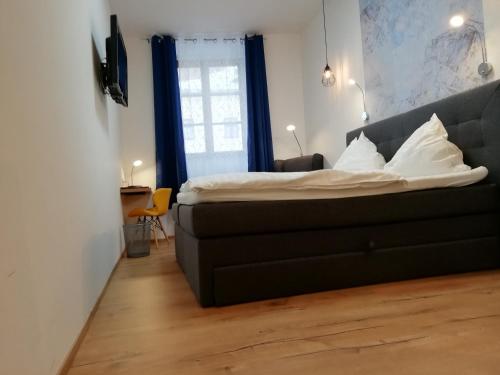 a bedroom with a black bed with white pillows at Hotel Zum Goldenen Hirschen in Freistadt
