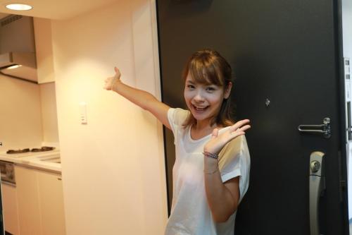 a young girl standing in a door with her arm up at IBASHO ShibuyaDogenzaka810 in Tokyo