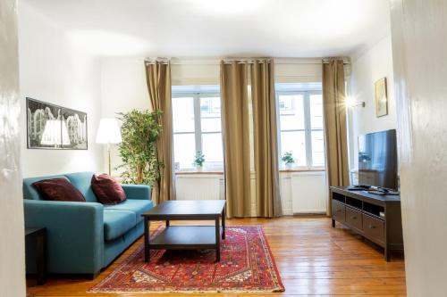 un soggiorno con un divano blu e un tavolo di ApartDirect Gamla Stan a Stoccolma