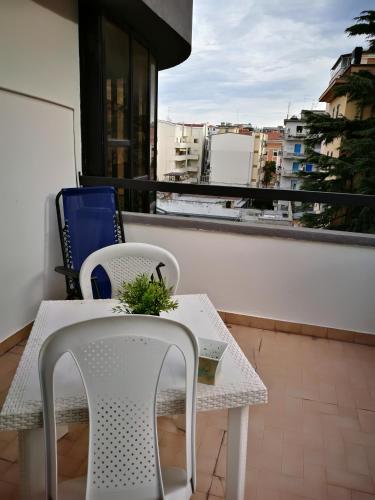 a table with two chairs and a laptop on a balcony at Blue Apartment in Pescara