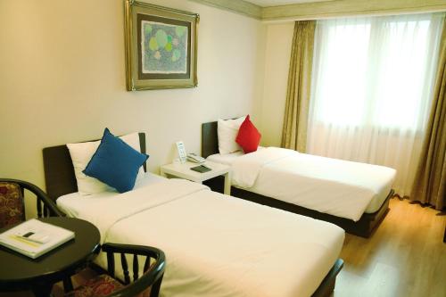 a room with two beds and a table and a window at Lavita hotel in Seoul