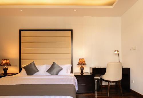 a bedroom with a bed and a desk and a chair at Lavonca Boutique Hotel in Colombo