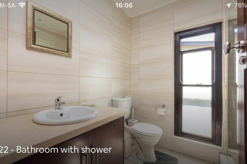 a bathroom with a sink and a toilet and a mirror at Forest Haven in Johannesburg