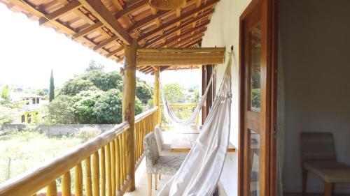 a porch with a hammock on a balcony at Casa do Capão in Vale do Capao