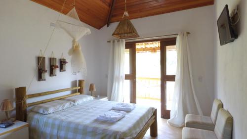 a bedroom with a bed and a sliding glass door at Casa do Capão in Vale do Capao