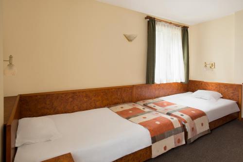 a bedroom with two beds and a window at Victoria Hotel Borovets - Free Parking in Borovets