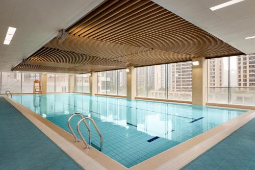 - une grande piscine dans un bâtiment doté de fenêtres dans l'établissement Hyatt House Chengdu Pebble Walk, à Chengdu