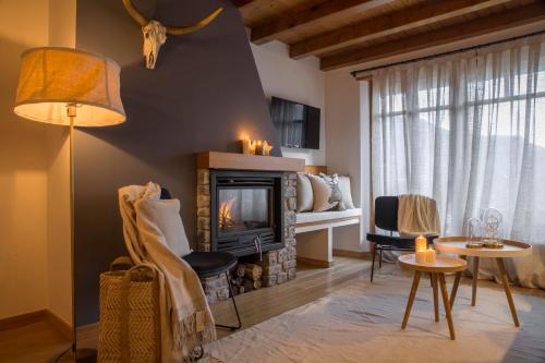 uma sala de estar com lareira e uma mesa e cadeiras em BARN THE RETREAT Apartamento premium en Esterri em Esterri d'Àneu