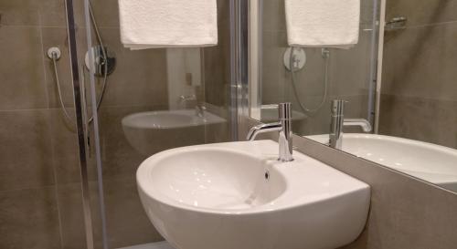 bagno con lavandino e doccia in vetro di Garda Rooms a Desenzano del Garda