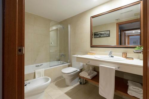 W łazience znajduje się umywalka, toaleta i lustro. w obiekcie Apartamento Camp Nou 101 w mieście Hospitalet de Llobregat