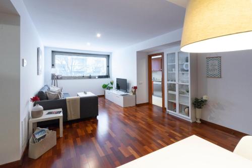 ein Wohnzimmer mit einem Sofa und einem Tisch in der Unterkunft Apartamento Camp Nou 101 in Hospitalet de Llobregat