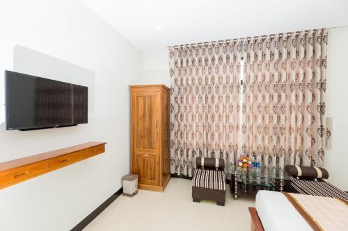 HUNG GIA HOTEL في كوي نون: غرفة معيشة مع تلفزيون بشاشة مسطحة وطاولة