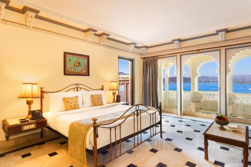 a bedroom with a bed and large windows at Shiv Niwas Palace by HRH Group of Hotels in Udaipur