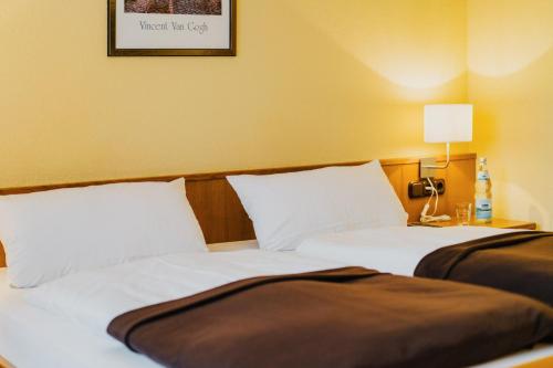 two beds sitting next to each other in a room at Hotel Achtermann in Braunlage