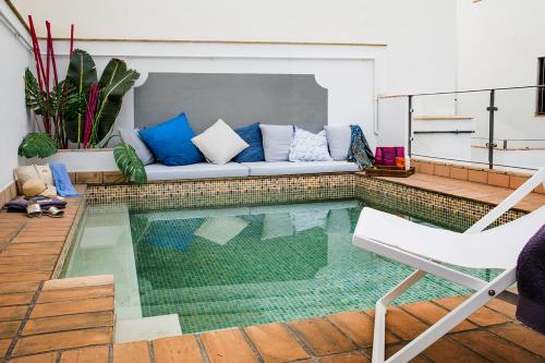 sala de estar con sofá y piscina en Matahacas Pool & Luxury, en Sevilla