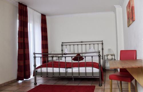 a bedroom with a bed with a red blanket at Akazienhof Hotel & Brauhaus in Cologne