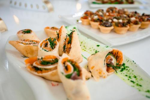 a plate of food on a table with appetizers at Almaty Grand Erbil Hotel in Almaty