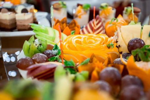 a pile of fruit and vegetables on a table at Almaty Grand Erbil Hotel in Almaty