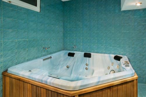 e bagno con vasca e piastrelle blu. di Victoria Hotel Borovets - Free Parking a Borovets