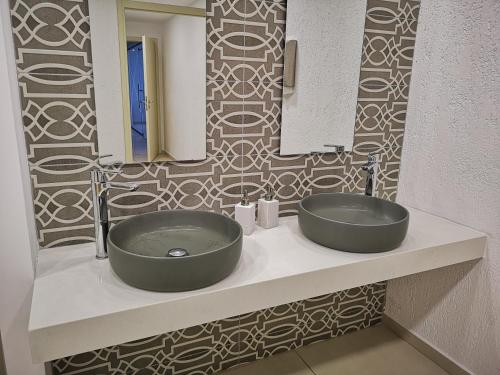 een badkamer met een wastafel en een spiegel bij Dimitra Hotel in Chersonissos