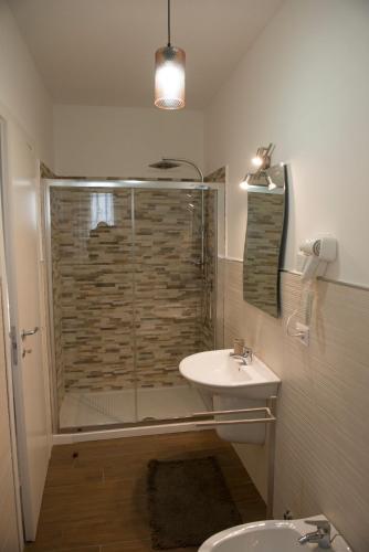 a bathroom with a glass shower and a sink at Villa Miriade B&b in Paestum
