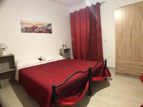 um quarto com uma cama vermelha e uma cortina vermelha em Holiday park Home em San Leone