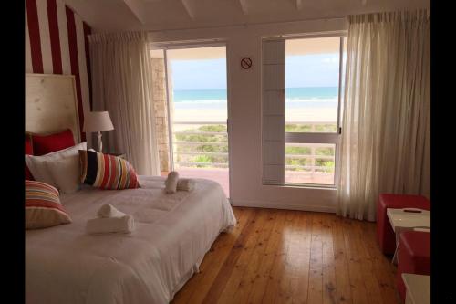 a bedroom with a bed with a view of the ocean at Villa Amore in Paternoster