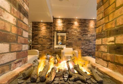 a fireplace in a living room with a brick wall at Best Western Hotel Trier City in Trier