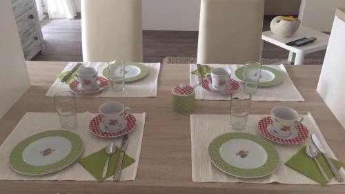una mesa con platos y tazas verdes y blancos en Fronhof 3 en Nierstein