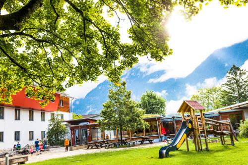 a playground in a park with mountains in the background at Jugendherberge Garmisch-Partenkirchen - membership required! in Garmisch-Partenkirchen