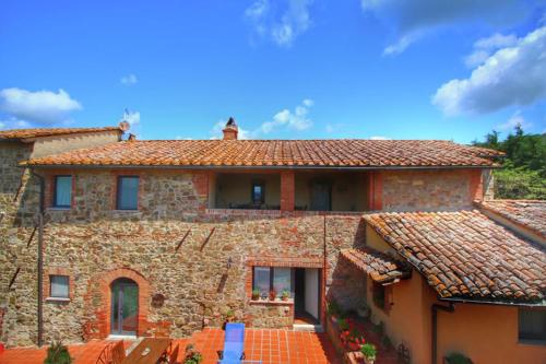 a large stone house with red roof at Podere Il Tigliolo in Castiglione dʼOrcia