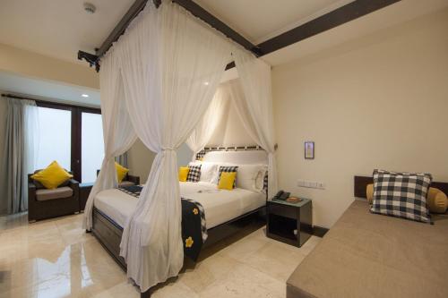 a bedroom with a bed with a canopy at Legian Beach Hotel in Legian