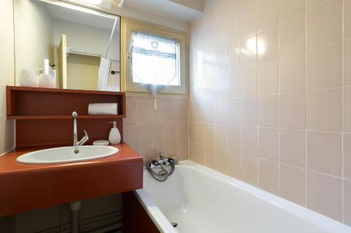une salle de bain avec un lavabo et une baignoire dans l'établissement Apartment Lognan 6 Centre Chamonix Mont Blanc, à Chamonix-Mont-Blanc