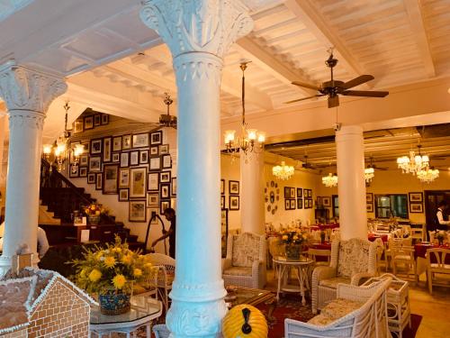 a lobby with columns and tables and chairs at The Elgin Fairlawn, Kolkata in Kolkata