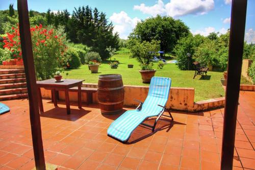 a blue chair sitting on a patio with a table at Podere Il Tigliolo in Castiglione dʼOrcia