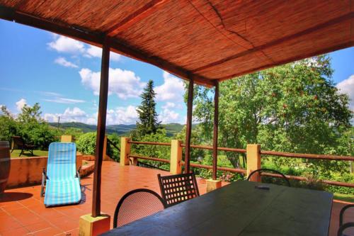 a patio with a table and chairs on a deck at Podere Il Tigliolo in Castiglione dʼOrcia