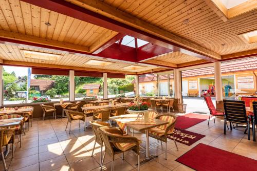 Kärntner Stubn في Paternion: مطعم بسقوف خشبية وطاولات وكراسي
