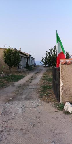 a flag on a fence next to a dirt road at Su Cuile historical country house with barbecue in Martis