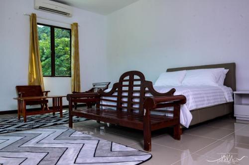 - une chambre avec un lit, un banc et une fenêtre dans l'établissement White House Langkawi, à Kuah