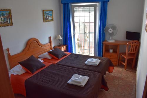 a bedroom with two beds with towels on them at La Fonda Aeropuerto in Ingenio