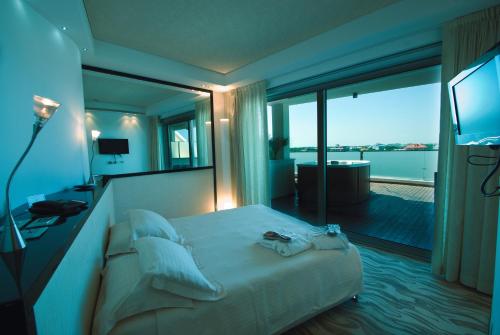 a hotel room with a bed and a large window at Hotel Premier & Suites - Premier Resort in Milano Marittima