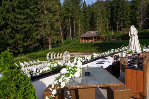 a long table with white chairs and white flowers at Teleferic Grand Hotel in Poiana Brasov