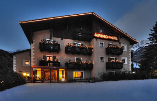 um edifício com um sinal na neve em Alpi & Golf Hotel em Bormio