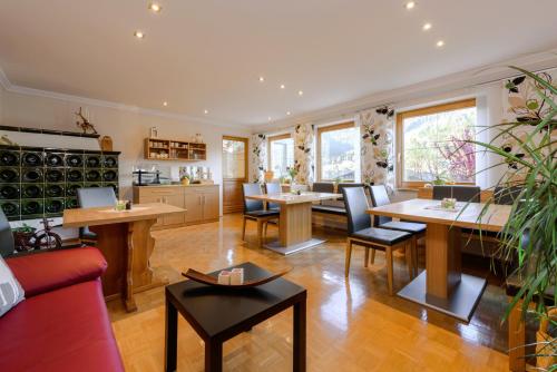a living room with tables and chairs and a kitchen at Haus Silvia in Flachau