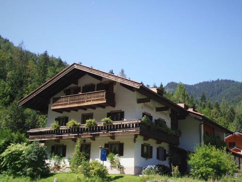 ein Haus in den Bergen mit Pflanzen auf den Balkonen in der Unterkunft Cosy little holiday home in Chiemgau balcony sauna and swimming pool in Ruhpolding